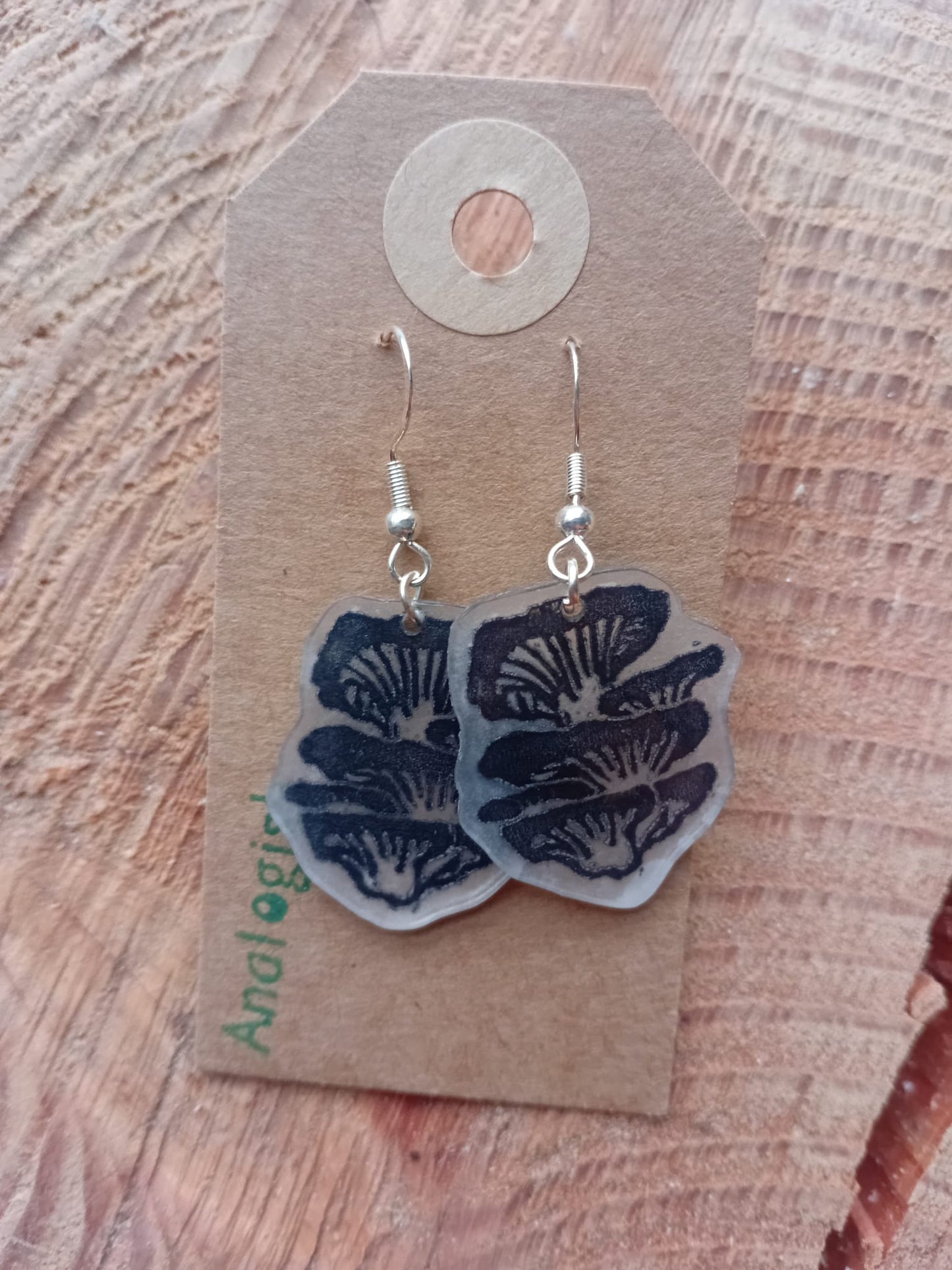 Oyster mushroom earrings on a wooden surface