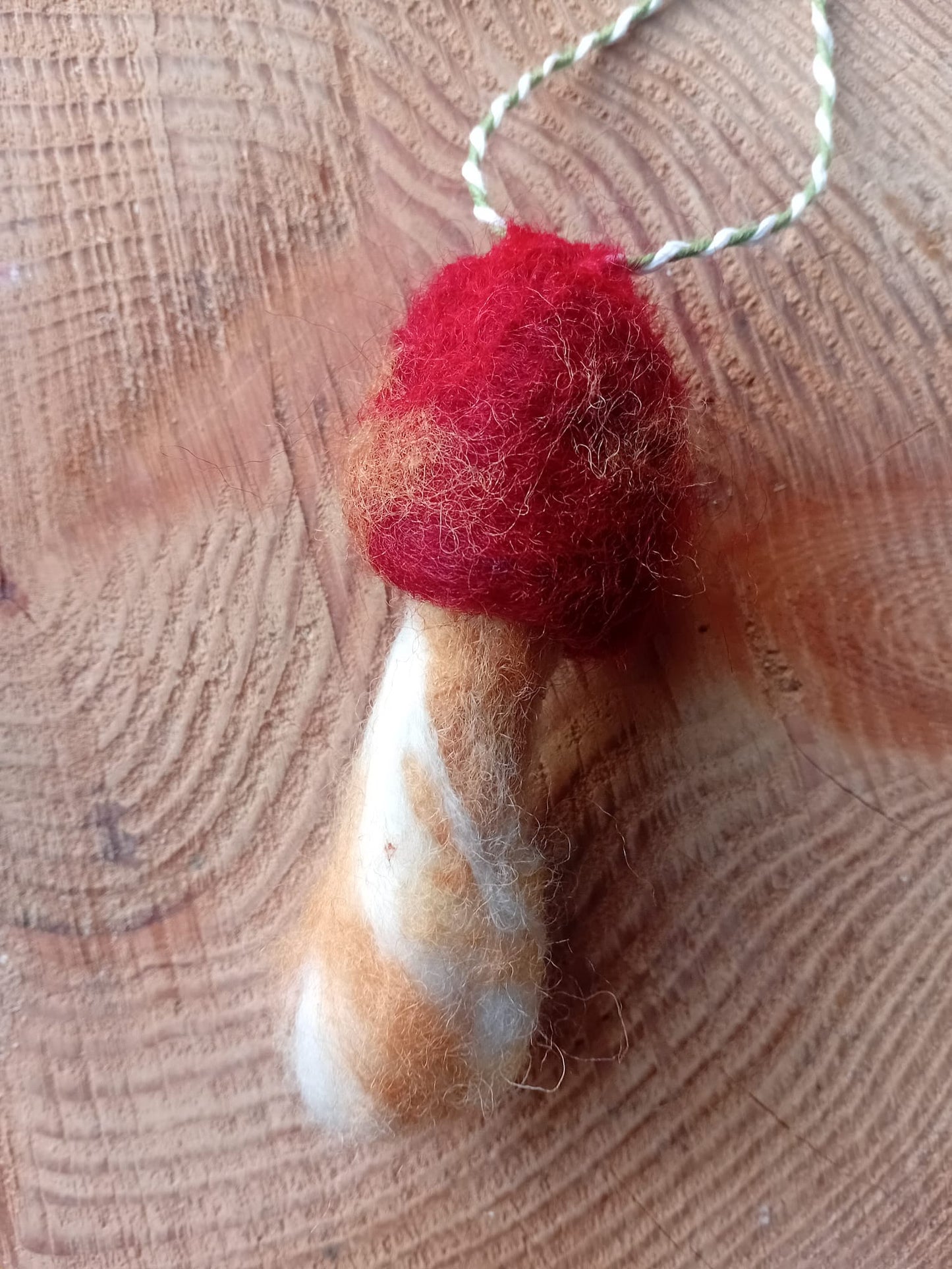 Hand felted russula emetica mushroom made by local artist @analogish against a tree stump back ground