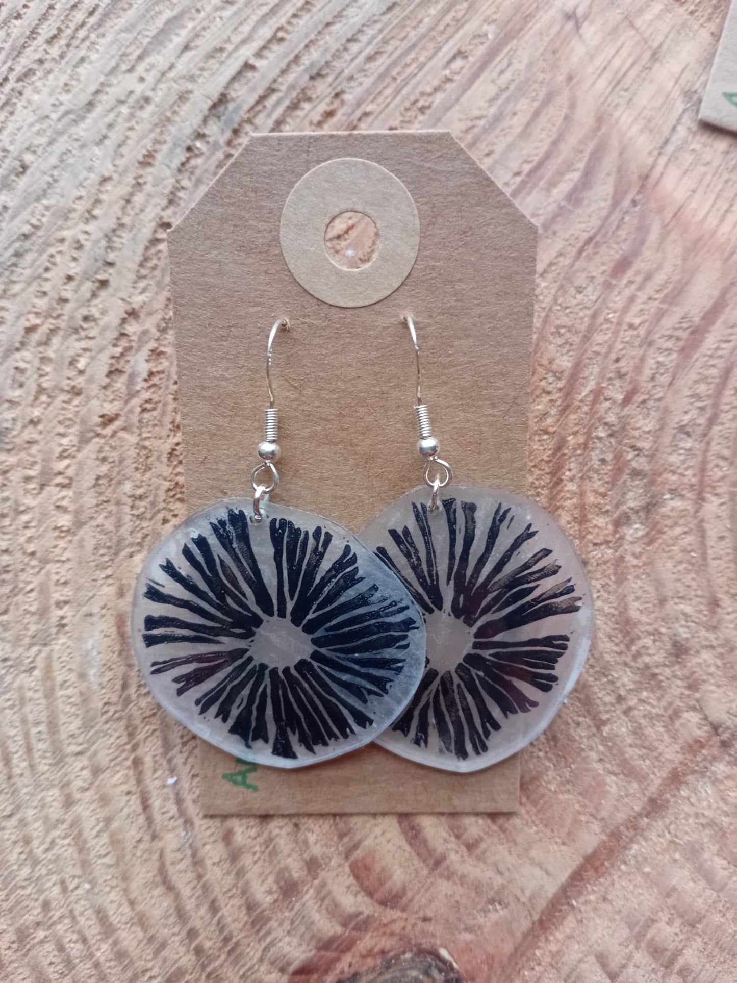 Pair of earrings with spore design on a cardboard backing