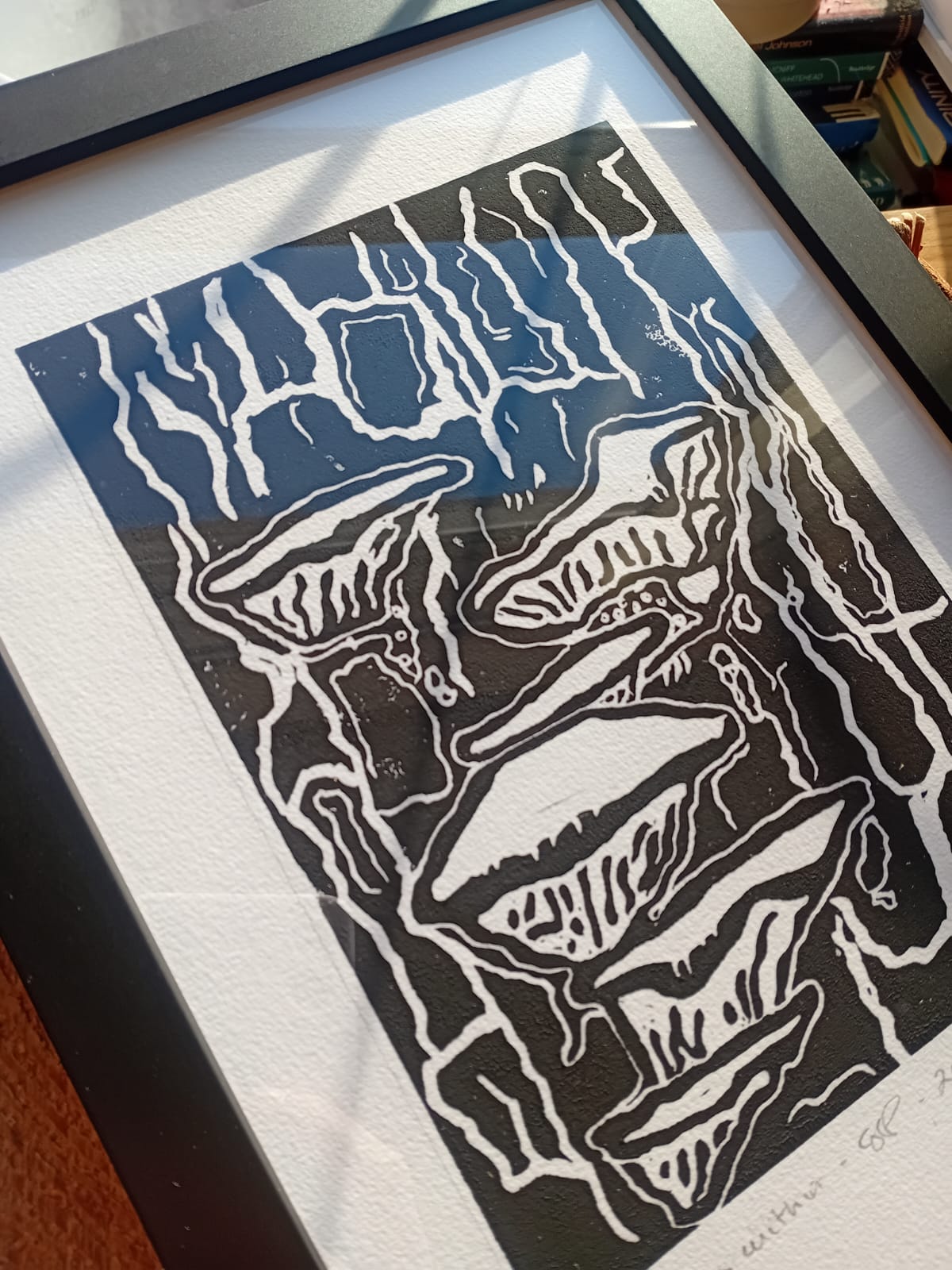Framed black and white abstract artwork on a textured surface