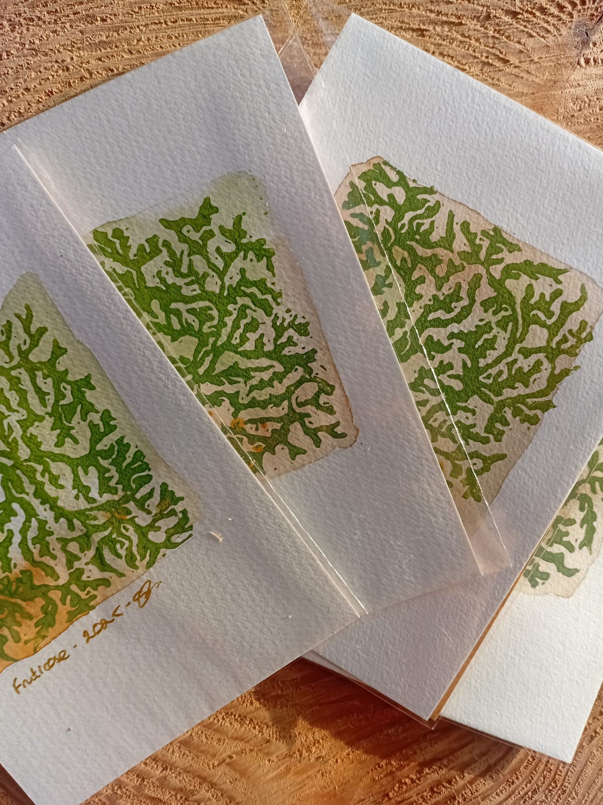 Green fruticose patterned print on a wooden surface.