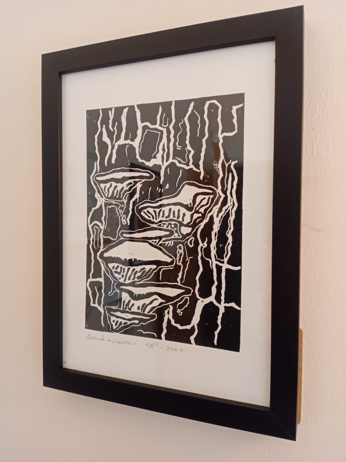 Framed artwork of mushrooms on a beige wall