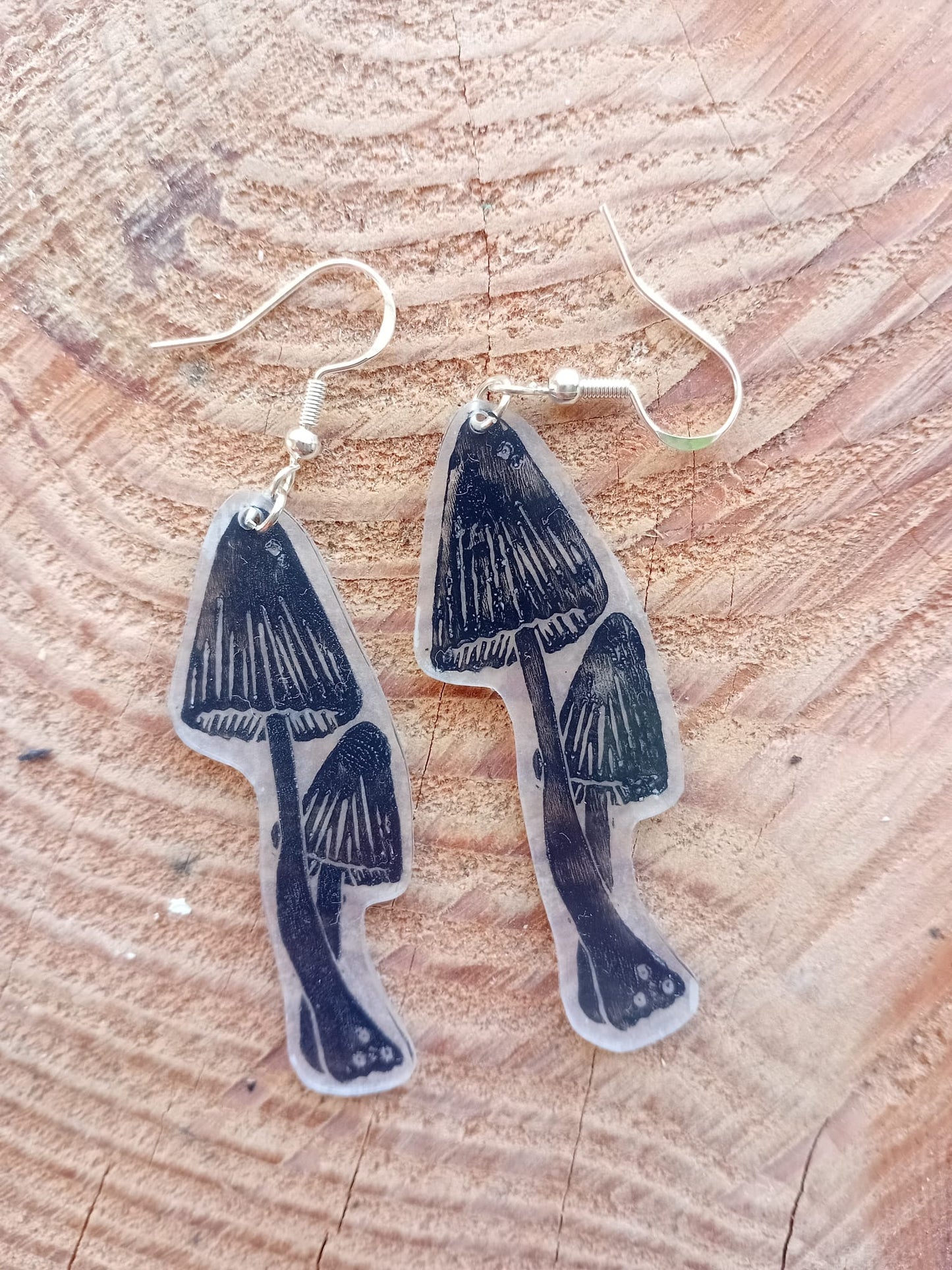Mushroom-shaped earrings on a wooden surface