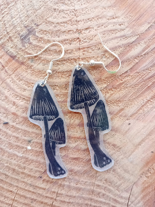 Mushroom-shaped earrings on a wooden surface