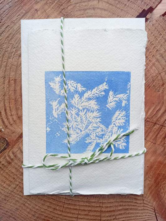 Original lino print card made with handmade paper depicting hoar frost on a wooden background. 