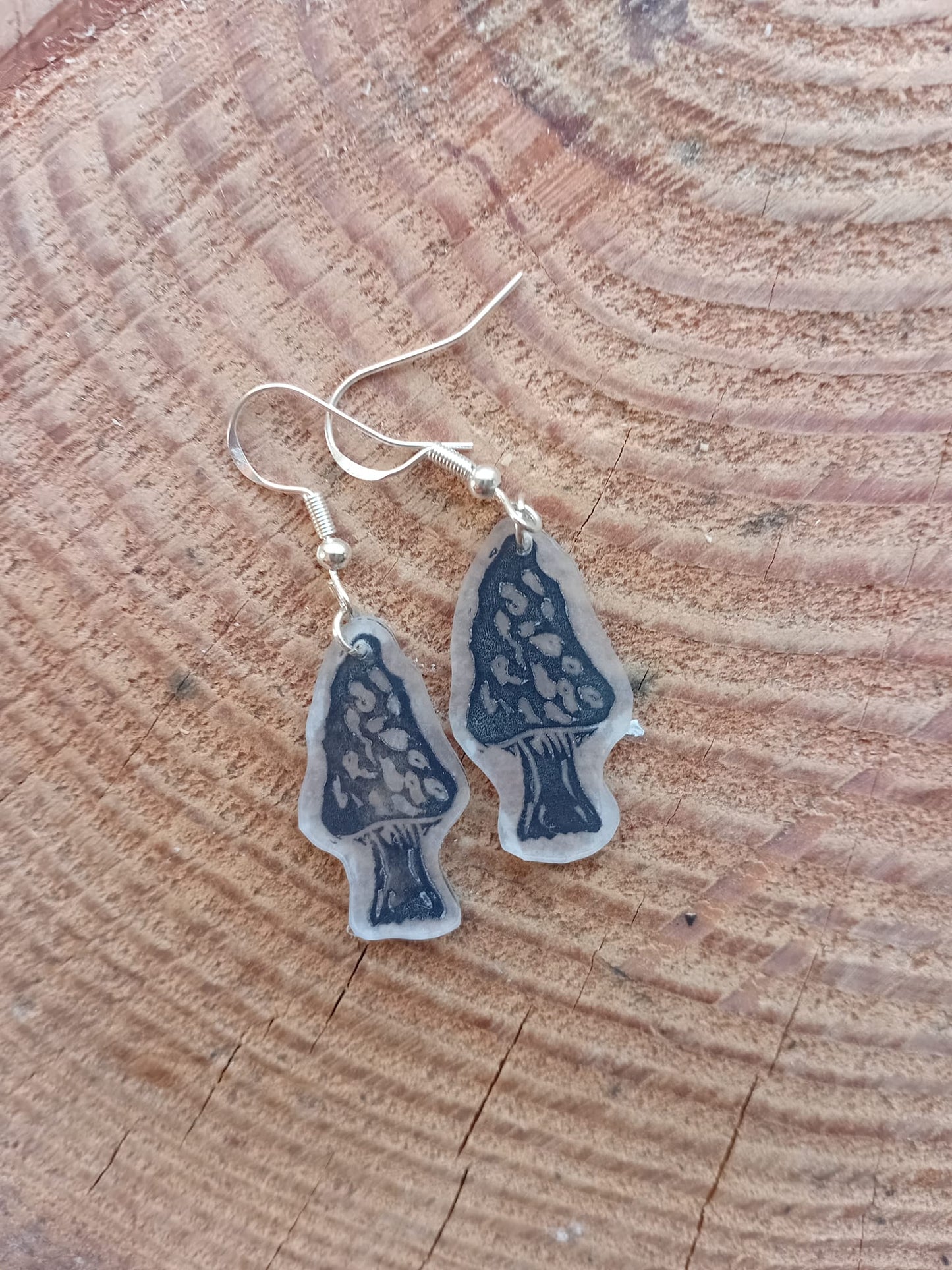 Pair of blue mushroom-shaped earrings on a wooden surface