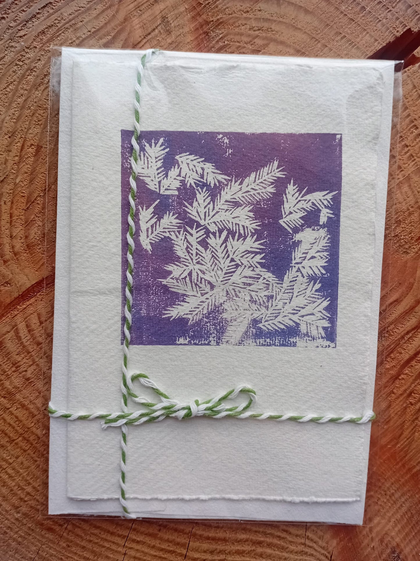 Card with purple and white design on a wooden surface