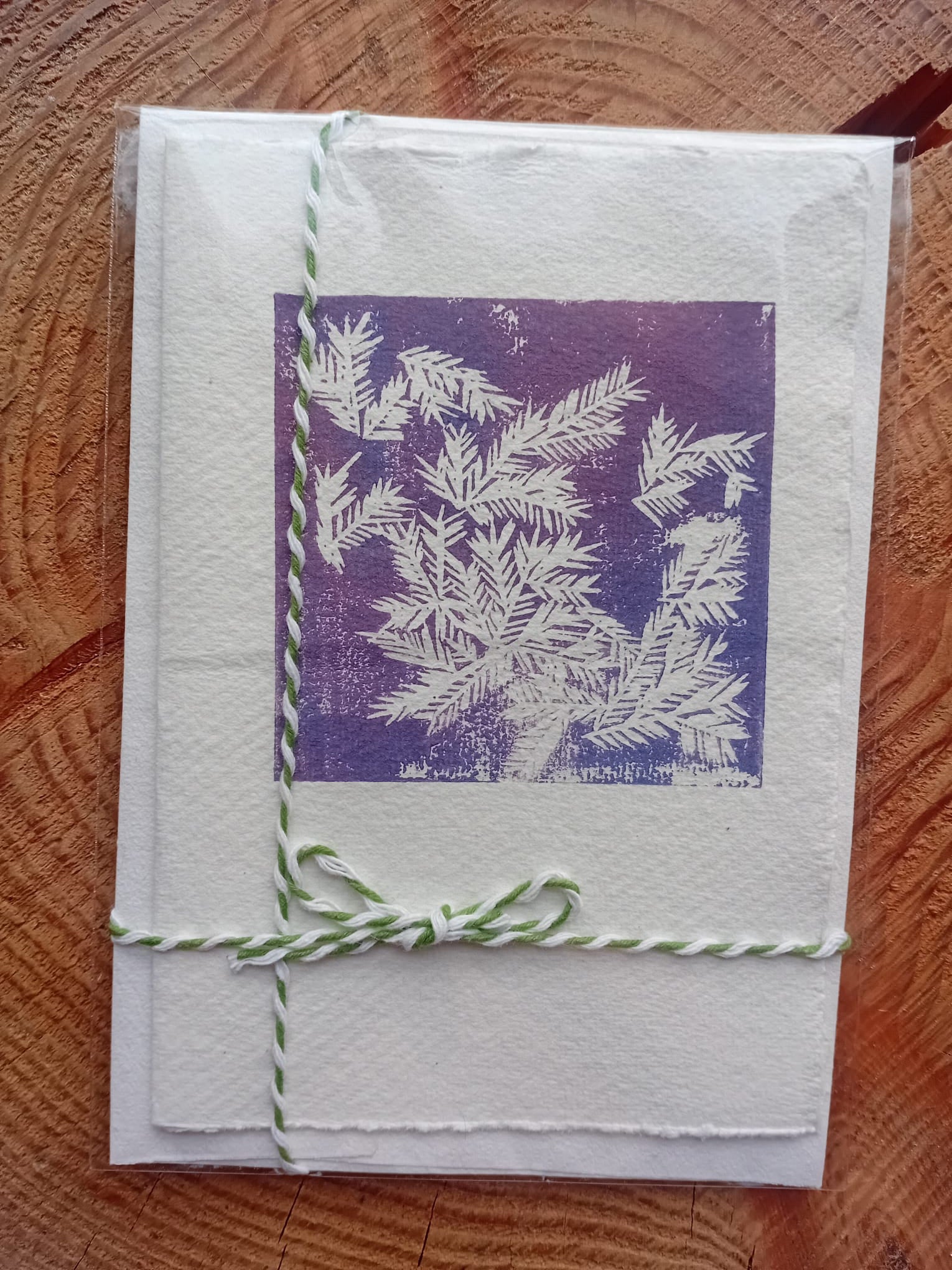 Card with purple and white design on a wooden surface